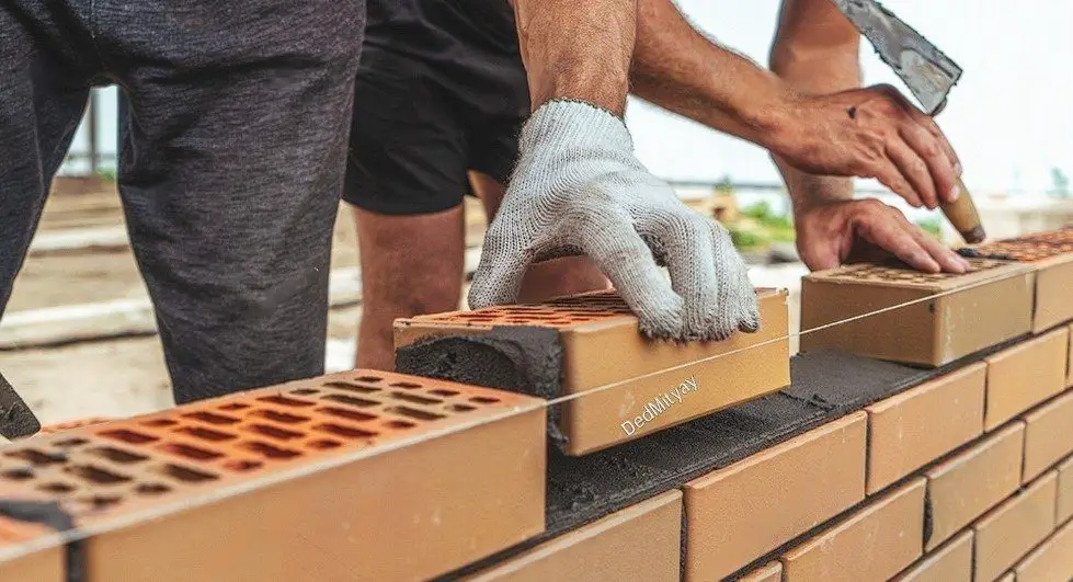 Mason hands laying bricks.Brickwork on construction site.