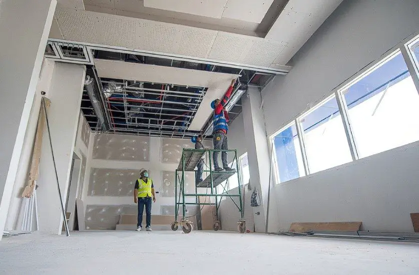 construction workers ongoing activity for acoustic suspended ceiling