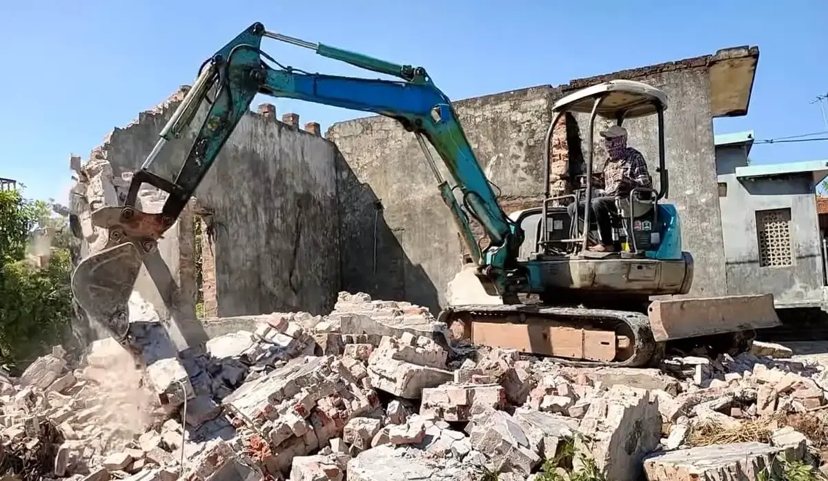 demolition of the building being done by a backhoe