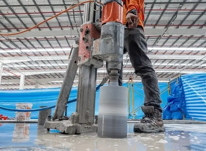 worker using concrete cutter on the slab