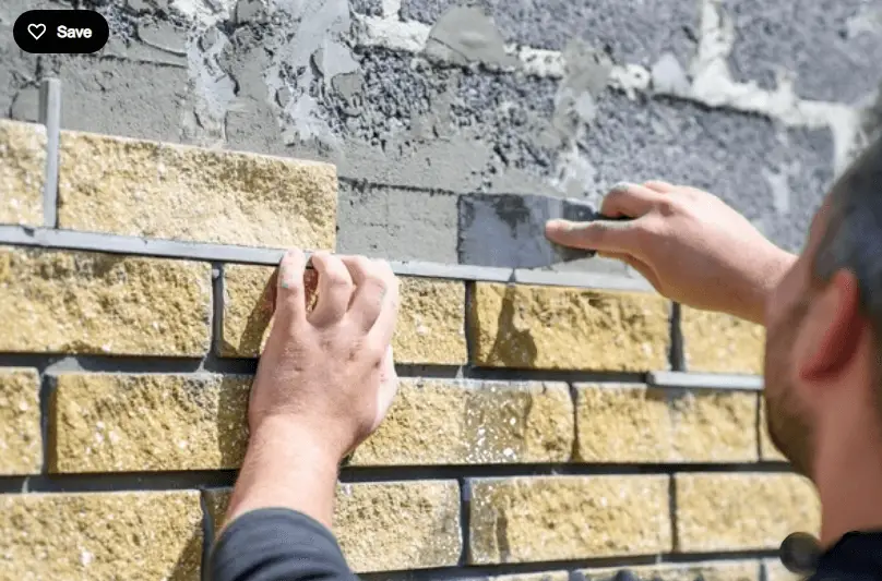 worker installing stone cladding