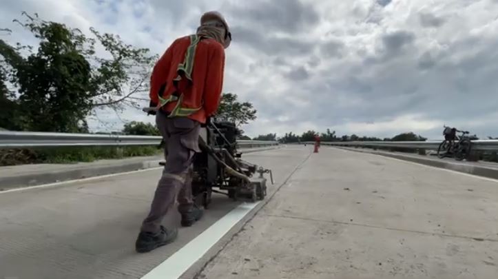 worker applying road marking on the concrete road